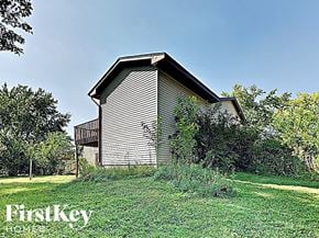 Frankfort house for rent - a small wooden barn with a deck on a grass field