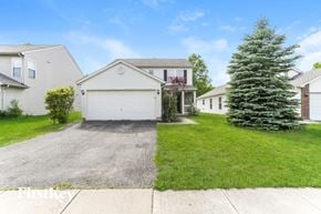 Grove City house for rent - A house with a garage and a tree in front.