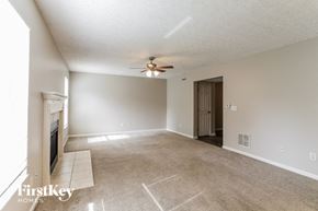 Grove City house for rent - A spacious living room with a fireplace and a ceiling fan.