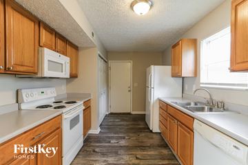 Grove City house for rent - A kitchen with wooden cabinets and white appliances.