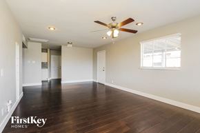 Phoenix house for rent - A spacious room with a ceiling fan and hardwood floors.