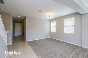 San Tan Valley house for rent - A spacious room with a carpeted floor and a chandelier hanging from the ceiling.