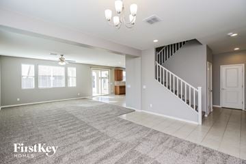 San Tan Valley house for rent - A spacious living room with a staircase and a rug on the floor.