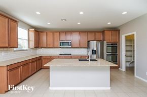 San Tan Valley house for rent - A kitchen with brown cabinets and a white island.