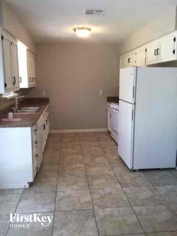 Denton house for rent - a kitchen with a white refrigerator and a sink