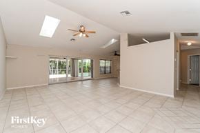 Cape Coral house for rent - a empty living room with a ceiling fan and a tile floor