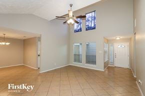 Humble house for rent - an empty living room with a ceiling fan and windows