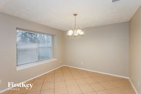 Humble house for rent - an empty dining room with a large window and a chandelier