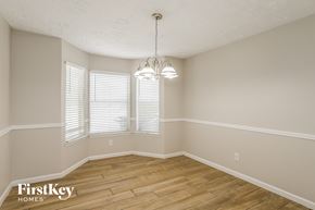 Humble house for rent - the spacious dining room with hardwood flooring and windows