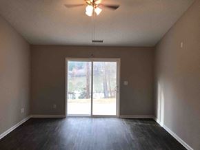 Kannapolis house for rent - A room with a ceiling fan and sliding glass doors.