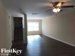 Charlotte house for rent - an empty living room with a ceiling fan