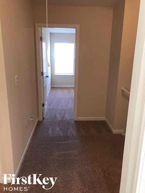 Charlotte house for rent - a hallway with a carpeted floor and a door to a bedroom