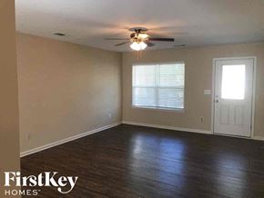 Charlotte house for rent - an empty living room with a ceiling fan and a window