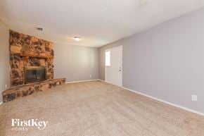 Garland house for rent - A living room with a fireplace and carpeting.