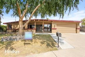 Phoenix house for rent - a house with a tree and a chair in front of it