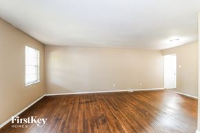 Florissant house for rent - A room with wooden floors and two windows.