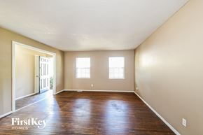 Florissant house for rent - A room with wooden floors and two windows.
