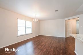 Spring house for rent - A room with wooden floors and a chandelier.