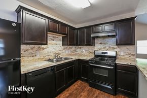 Spring house for rent - A kitchen with black appliances and cabinets.