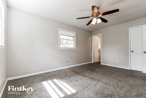 Decatur house for rent - A spacious room with a ceiling fan and two windows.