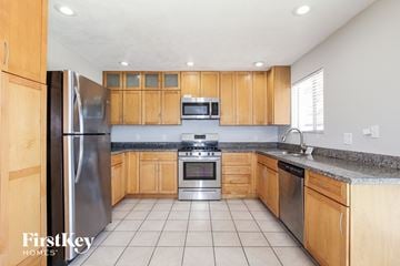 Phoenix house for rent - a kitchen with wooden cabinets and stainless steel appliances