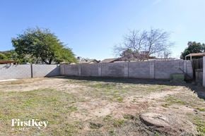 Phoenix house for rent - the backyard of a house with a concrete fence and a yard with grass