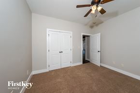 Calera house for rent - a bedroom with two closets and a ceiling fan