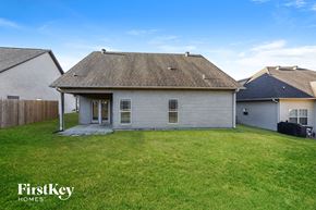 Calera house for rent - a backyard with a white house and a grassy yard