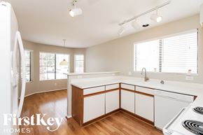Glendale house for rent - a kitchen with white cabinets and white appliances and a wood floor