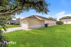 Lakeland house for rent - a home with a garage and a yard with a tree