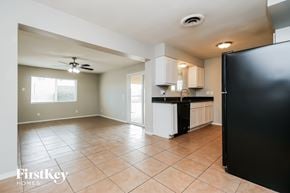 Mesa house for rent - A kitchen with a black refrigerator and a ceiling fan.