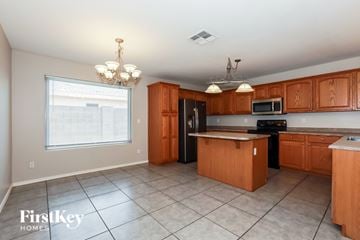 Queen Creek house for rent - A kitchen with wooden cabinets and a black refrigerator.