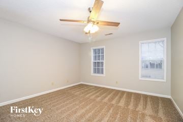 Winston-Salem house for rent - a spacious living room with carpet and a ceiling fan