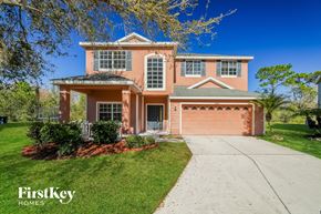 Tampa house for rent - a pink house with a sidewalk in front of it