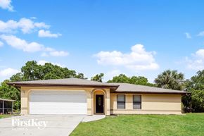 Port Charlotte house for rent - A two-car garage with a beige house in the background.
