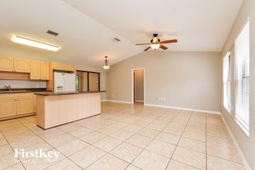 Port Charlotte house for rent - A kitchen with wooden cabinets and a beige island.
