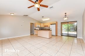 Port Charlotte house for rent - A spacious room with a ceiling fan and a kitchen area in the background.