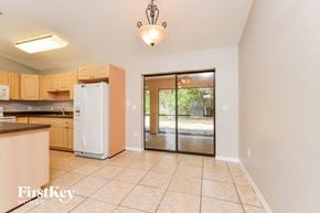 Port Charlotte house for rent - A kitchen with a refrigerator, cabinets, and a chandelier.
