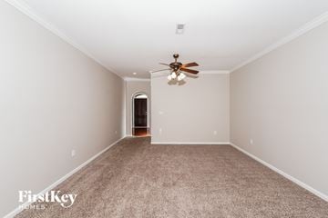 Moody house for rent - a spacious living room with carpet and a ceiling fan