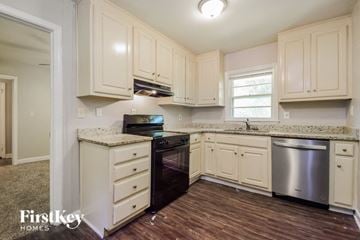 Decatur house for rent - a kitchen with white cabinets and black appliances and a wooden floor