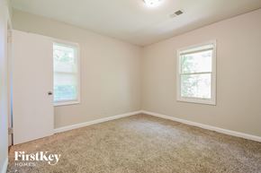 Decatur house for rent - a bedroom with a carpeted floor and two windows