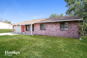 Deltona house for rent - A red brick house with a white door and a small porch.