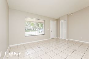 Deltona house for rent - A spacious room with a large window and sliding glass doors.