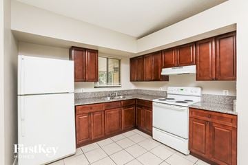Deltona house for rent - A kitchen with white appliances and brown cabinets.