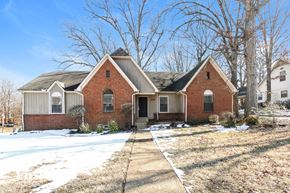 Cordova house for rent - A red brick house with a white garage door and a small front porch.