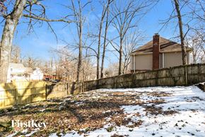 Cordova house for rent - A house with a brown roof is surrounded by a fence and leafless trees.