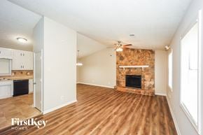Lithonia house for rent - A spacious room with a fireplace and wooden flooring.