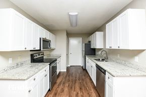 Euless house for rent - an empty kitchen with white cabinets and granite counter tops