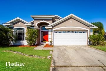 Kissimmee house for rent - a house with a white garage door in front of it