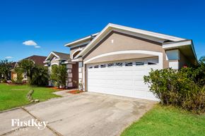 Kissimmee house for rent - a house with a white garage door in front of a driveway
